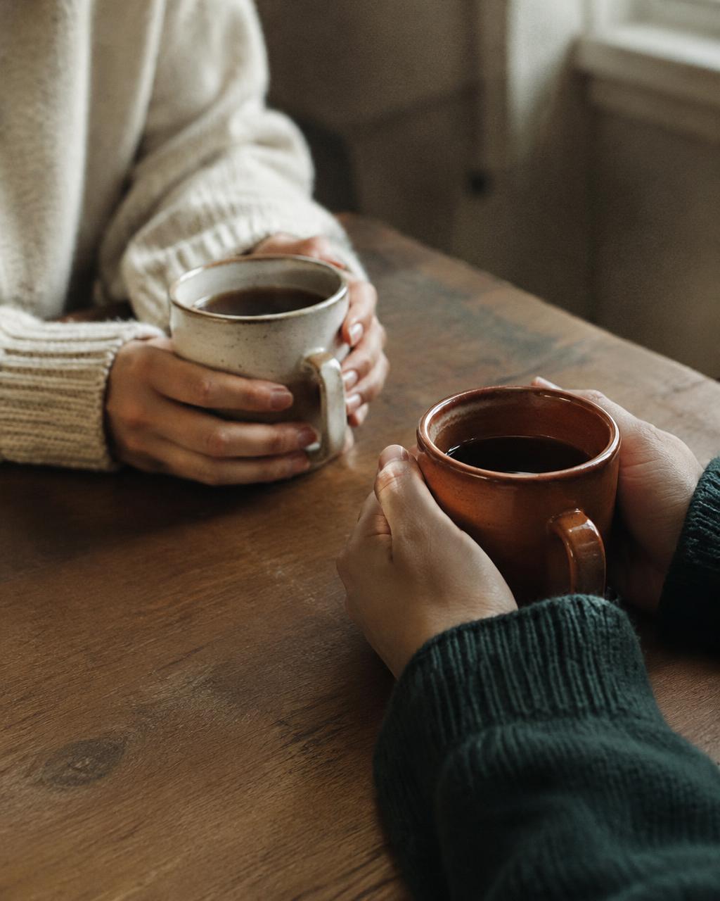 Two people sharing a conversation over coffee